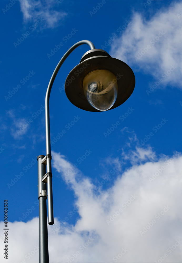 Street light. A large lamp against a cloudy blue sky. Lantern close-up. Street light. A large lamp against a cloudy blue sky. Lantern close-up.