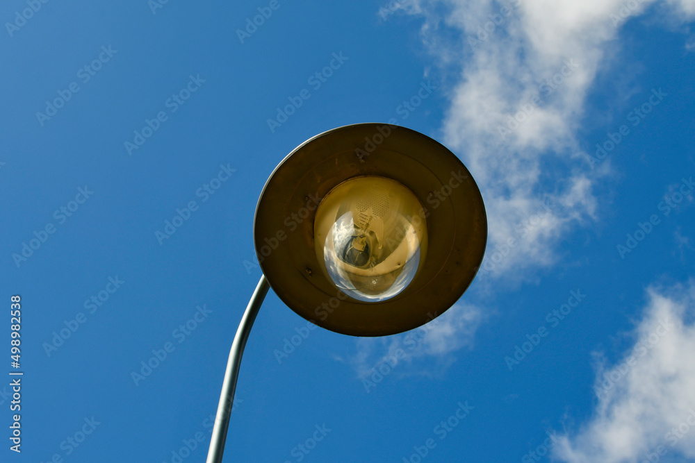 Street light. A large lamp against a cloudy blue sky. Lantern close-up.