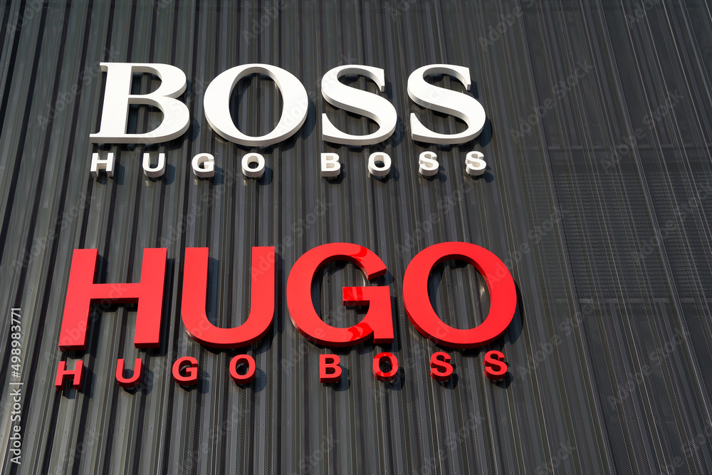 minimum salto Rudyard Kipling Hugo Boss Letters on a dark facade. Shopping in the outlet city metzingen.  Close up. Metzingen, Germany. Stock Photo | Adobe Stock