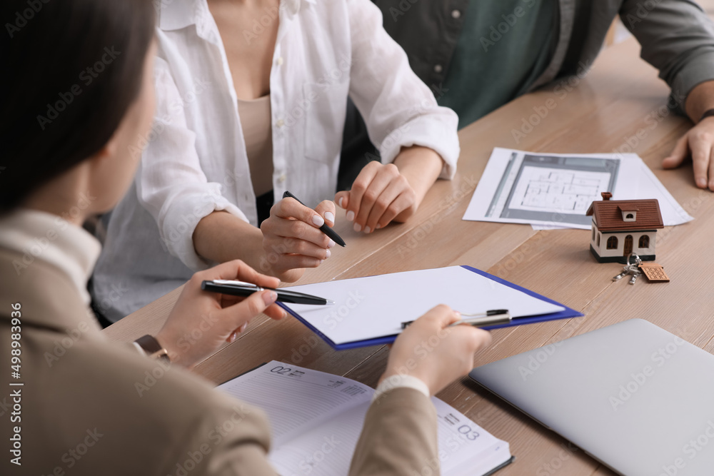 Εκτύπωση καμβά Young couple signing purchase contract in real estate agent's office, closeup