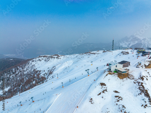 Aerial view of tourist attraction on snow covered mountain against blue sky