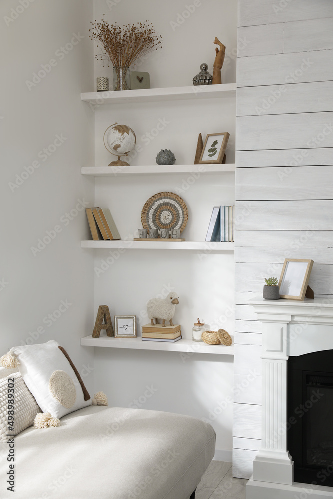 Many shelves with different decor near sofa in room. Interior design Many shelves with different decor near sofa in room. Interior design