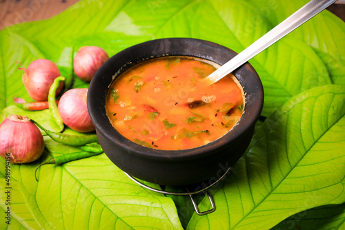 south indian famous rasam,sambar served in a traditional mud pot closeup with selective focus and blur