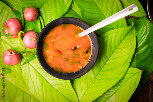 south indian famous rasam,sambar served in a traditional mud pot closeup with selective focus and blur photo