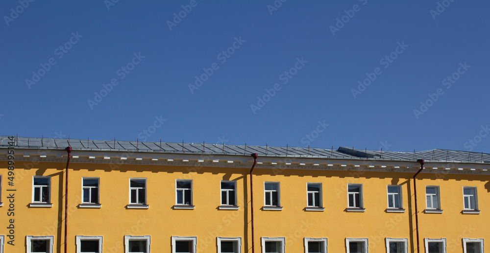 Ukrainian yellow house in Kyiv. Blue sky. Colors of the Ukrainian flag. Architecture of Ukraine background.