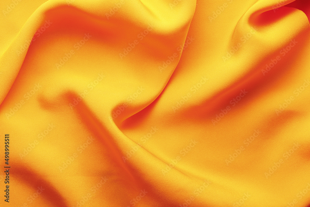 Bright orange fabric with wrinkles. Vivid fabric background with folds. The texture of the fabric. Dark background. Top view. Bright orange fabric with wrinkles. Vivid fabric background with folds. The texture of the fabric. Dark background. Top view.