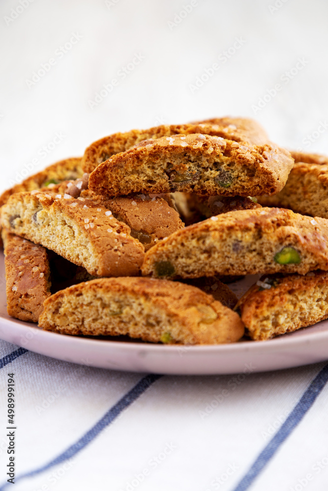 Homemade Italian Cantuccini with Pistachios and Citron on a Plate, side view. Crispy Pistachio and Citron Cookies. Close-up.