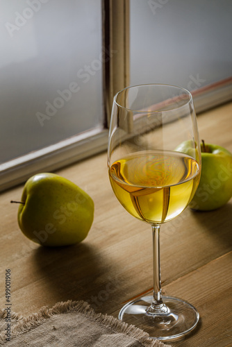 Glass of white wine and apples on wooden background, copy space