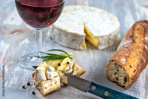 Tasting of a coulommiers with bread and a glass of wine on a table.