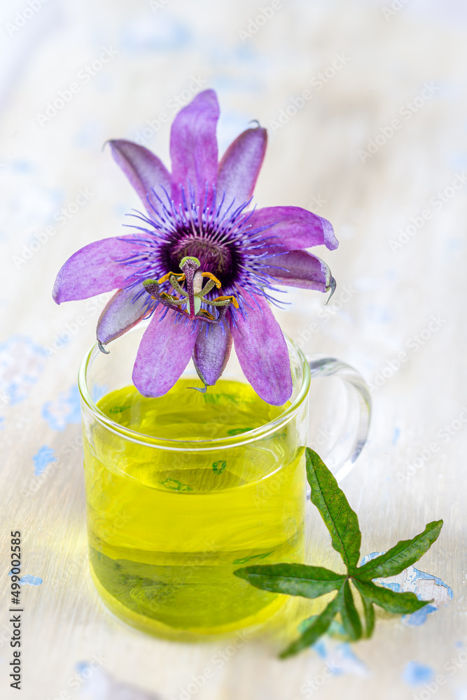 Close up of a passionflower flower infused in a glass cup on a board. Close up of a passionflower flower infused in a glass cup on a board.