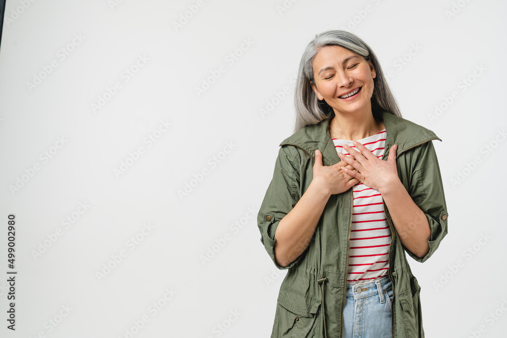 Pleased touched with a compliment caucasian mature middle-aged woman in casual clothes listening to praise isolated in white background - obrazy, fototapety, plakaty 
