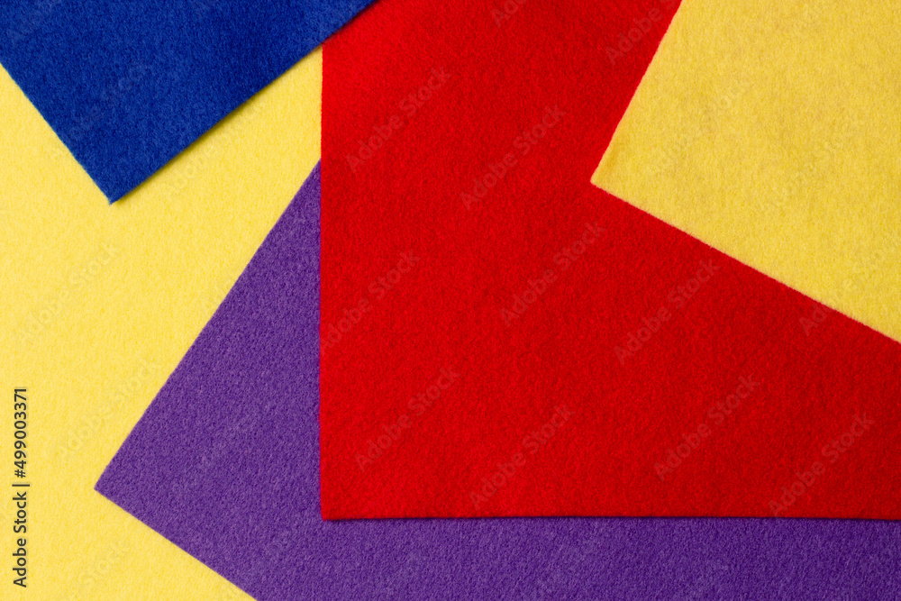 Abstract colorful geometric felt texture background. Bright yellow, blue, red, purple colors felt textile for craft. Top view, flat lay Abstract colorful geometric felt texture background. Bright yellow, blue, red, purple colors felt textile for craft. Top view, flat lay