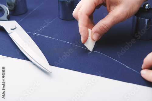 Tailor makes markings with chalk on the fabric. Clothes sewing. Tailoring. Close up view