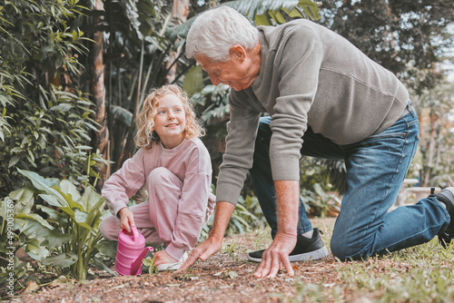 The mud washes away but the memories last forever. Shot of an adorable little girl gardening with her grandfather.
