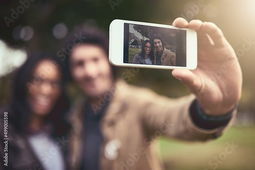 This one os for the memories. Shot of a cheerful young couple taking a self portrait together while standing outside in a park.