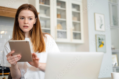 Female freelancer online learning education at home, uses laptop and internet site