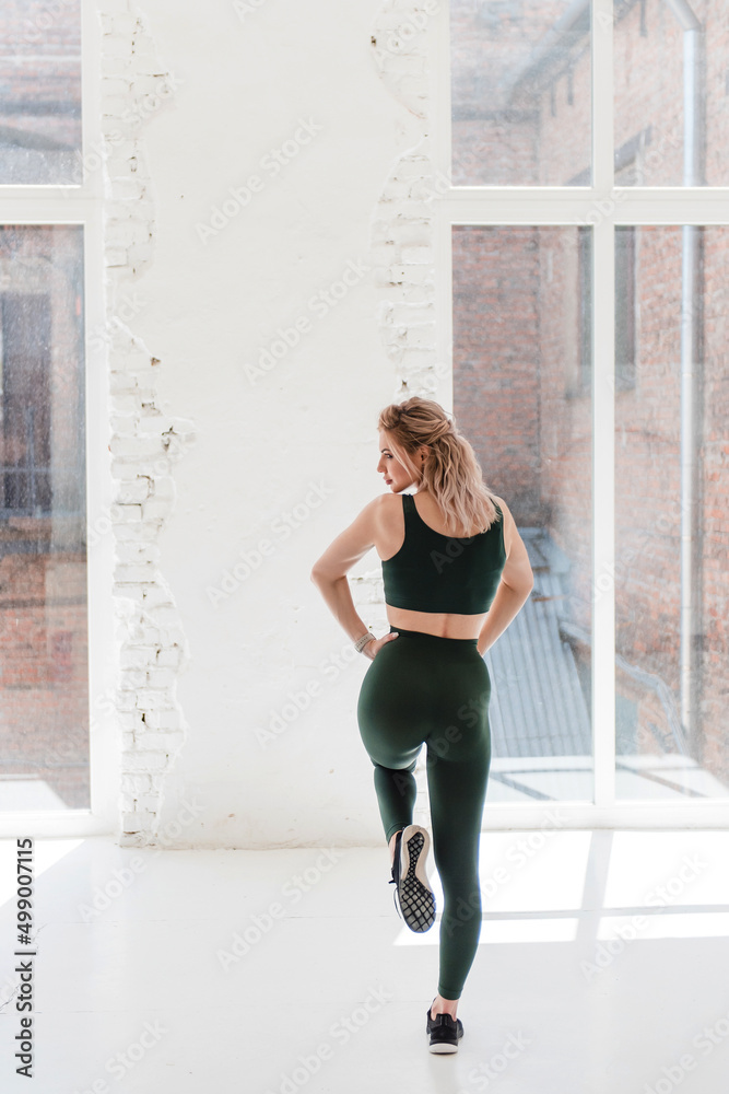 Obraz premium Confident active woman in sport clothing posing on camera