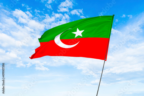 Pakistani Political party PTI flag, Pakistan Tehreek Insaf waving flag with blue sky in the background
