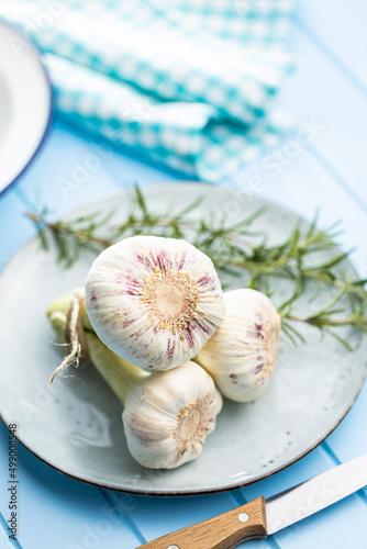 Whole garlic bulb. Fresh white garlic on blue table.