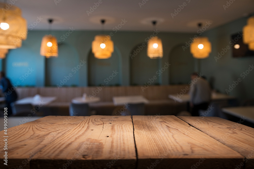 Empty wooden table top with lights bokeh on blur restaurant background. Empty wooden table top with lights bokeh on blur restaurant background.
