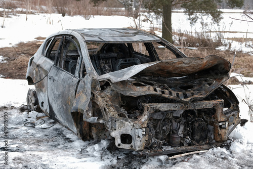 Burnt car with small flames inside of the engine. Burnt new car. malfunction that led to the death of the atomobile and people photo