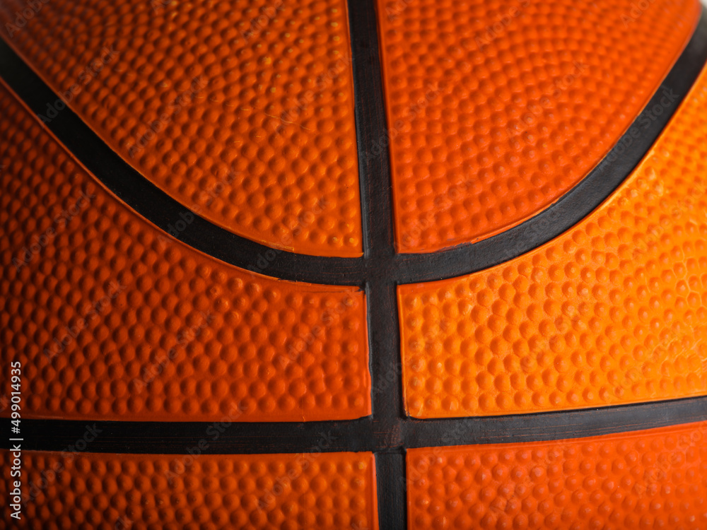 Fototapeta premium Details of an orange basketball. Macro shot. There are no people in the photo. Abstract Sports games, workouts, healthy lifestyle. Advertising. Banner. Invitation.