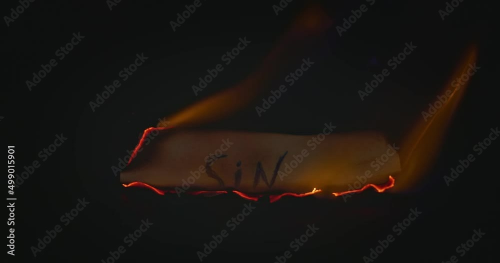 Closeup video of burning paper with SIN written on it