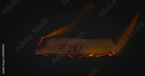 Closeup video of burning paper with SIN written on it