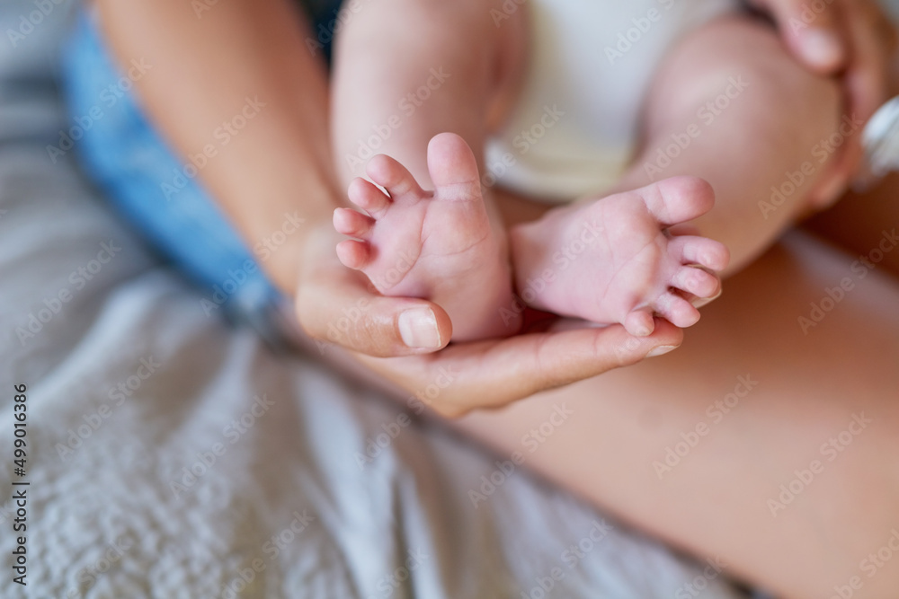 Soon theyll start walking.... Cropped shot of a mother holding her babys feet. Soon theyll start walking.... Cropped shot of a mother holding her babys feet.