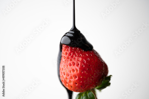 pouring chocokate sauce on strawberry