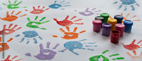 Colorful hand prints on white background with paints. Imprint of palm little children as a fun  play and education in kindergarten. Close up.