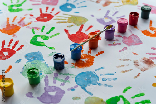 Hand prints in different color on white background with paints and brush. Colorful nhand print of little child. Education, play and fun. Art in kindergarten. photo