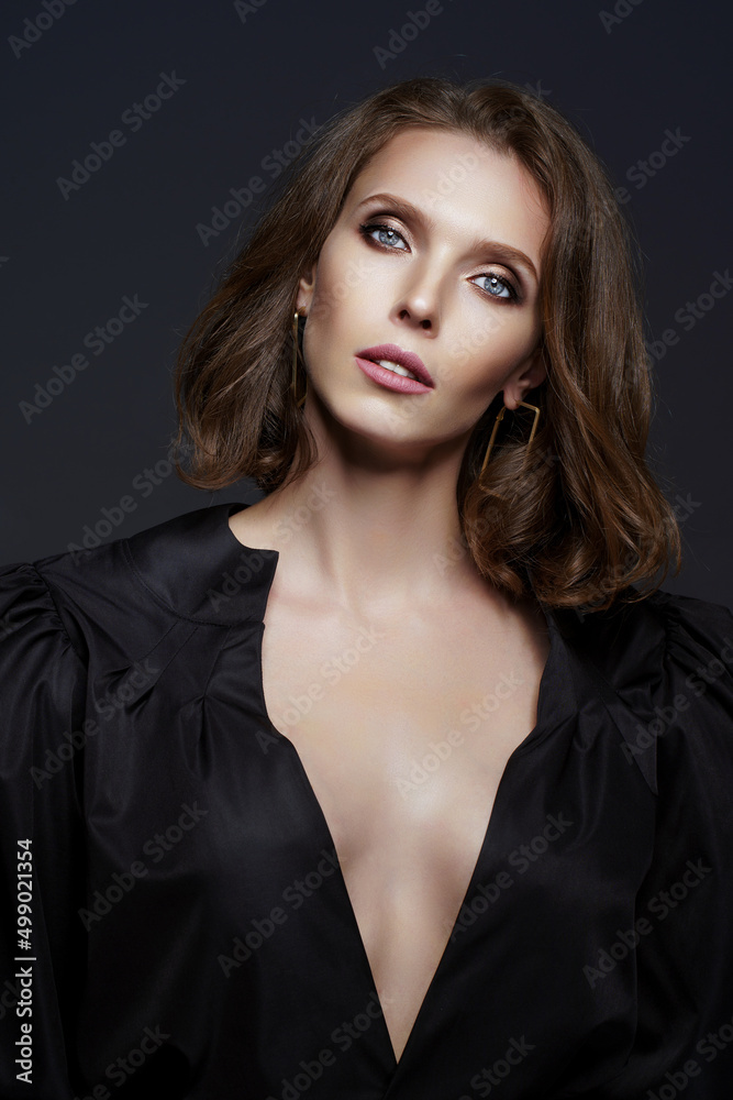 Studio shot of sexy brunette woman in black dress who isolated on dark background. Fashion photo Studio shot of sexy brunette woman in black dress who isolated on dark background. Fashion photo