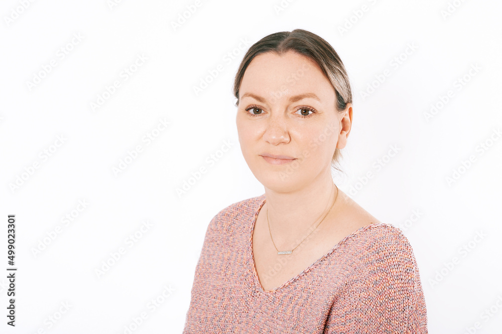 Studio portrait of pretty 35 - 40 year old woman, posing on white background