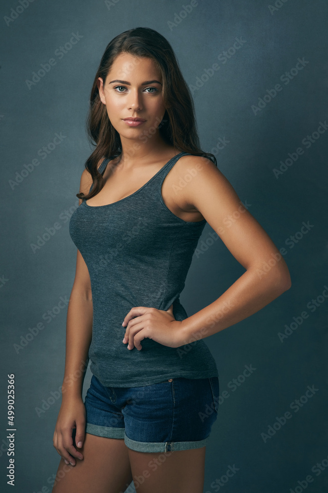 She is beyond beautiful. Studio shot of a beautiful young woman posing against a blue background. She is beyond beautiful. Studio shot of a beautiful young woman posing against a blue background.
