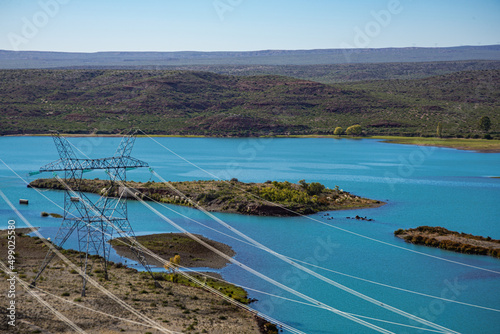 Patagonia landscape with a high-voltage hydroelectric power line on the banks of the Limay river  El Chocon  Neuquen Province  Argentina