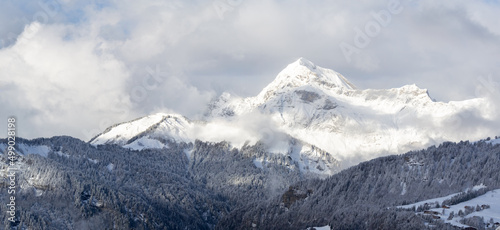 illustration d'un paysage de montagne sous la neige dans les nuages © emmanuel