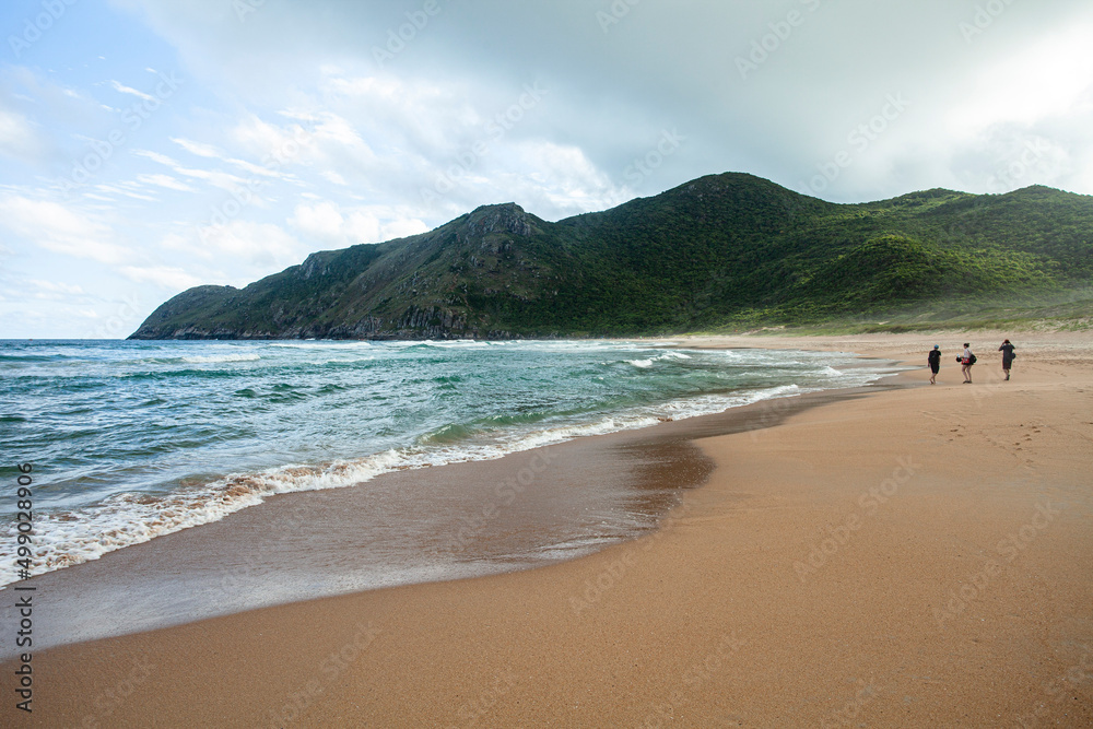 Obraz premium People walking on a deserted beach in Florianopolis