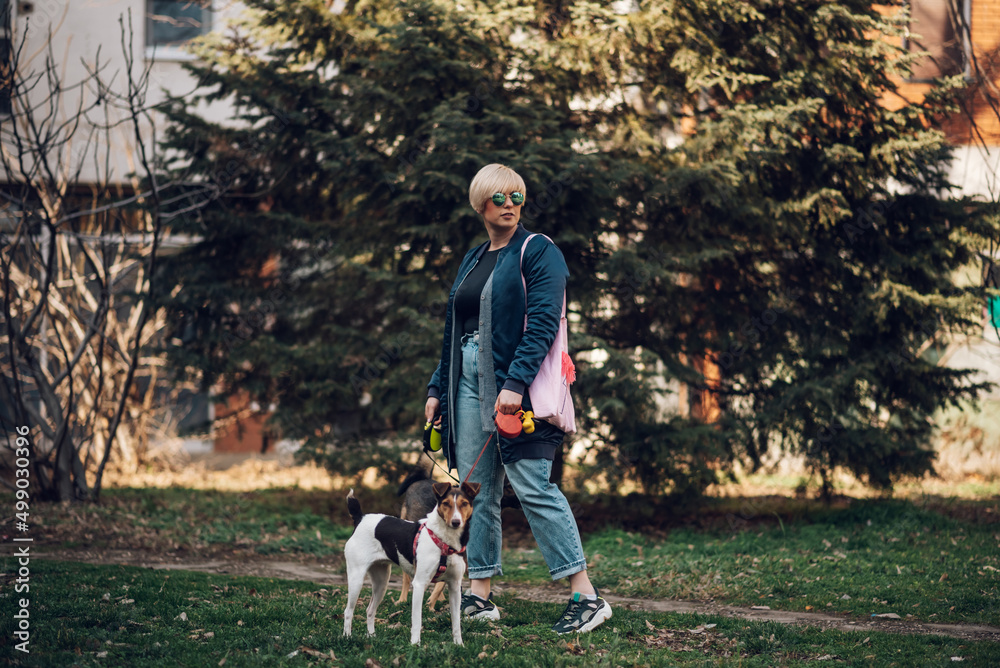 Woman walking her dogs on the city streets