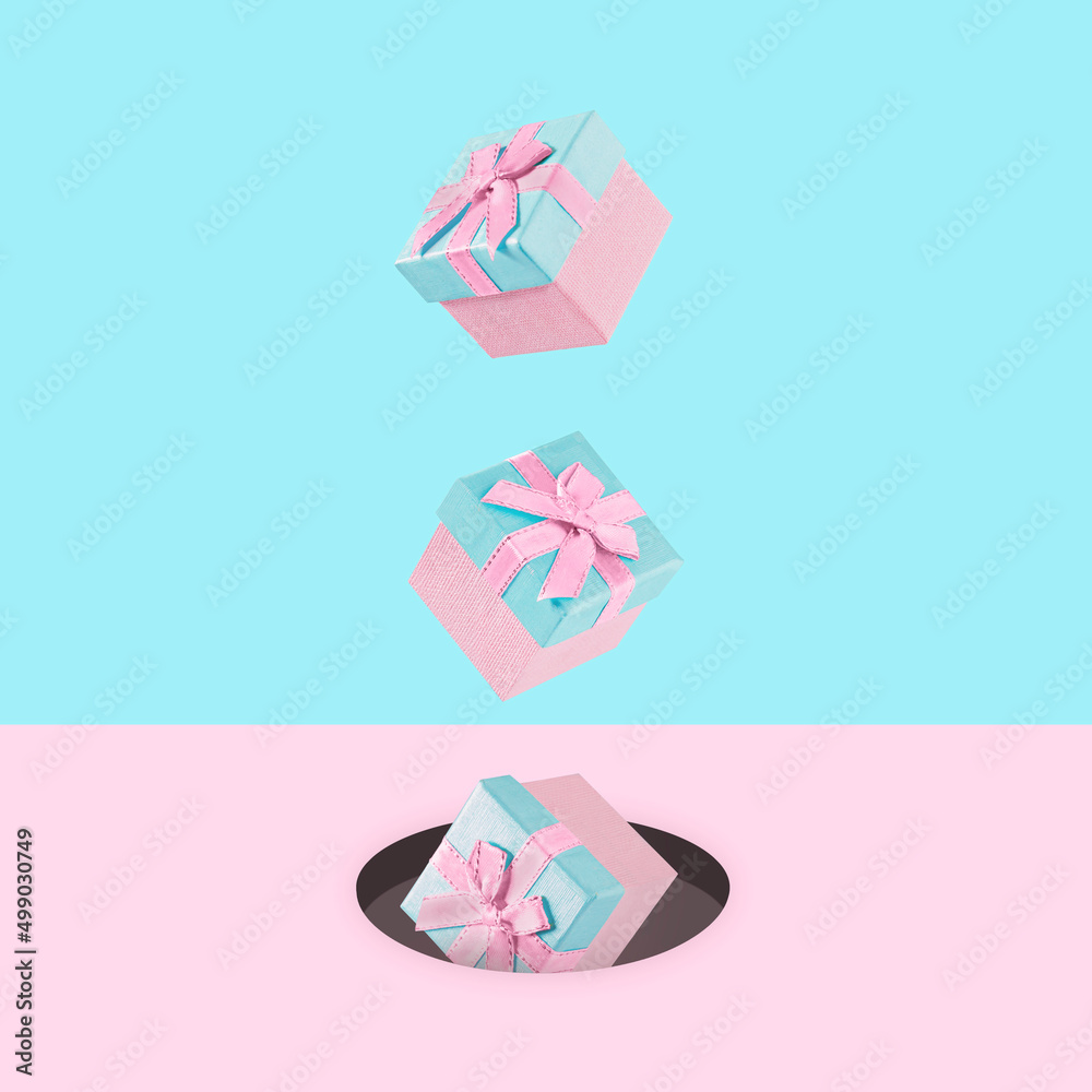 Pastel pink Christmas gift boxes on blue and pink backdrop falling down. . New Year present concept. Minimal composition Pastel pink Christmas gift boxes on blue and pink backdrop falling down. . New Year present concept. Minimal composition