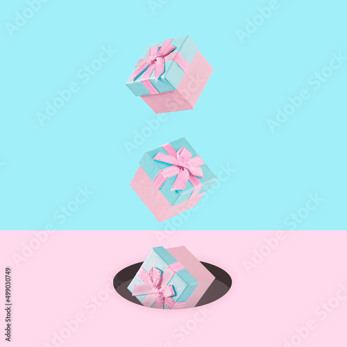 Pastel pink Christmas gift boxes on blue and pink backdrop falling down.  . New Year present concept. Minimal composition