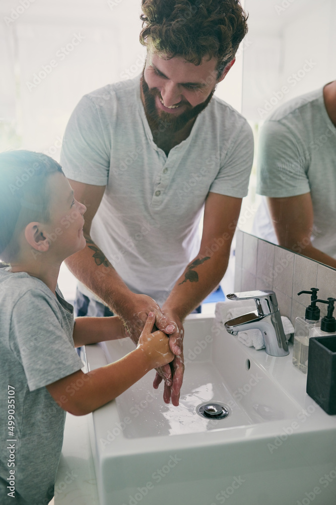 Every moment is a moment for bonding. Cropped shot of a young handsome father helping his adorable little boy wash his hands in the bathroom at home.