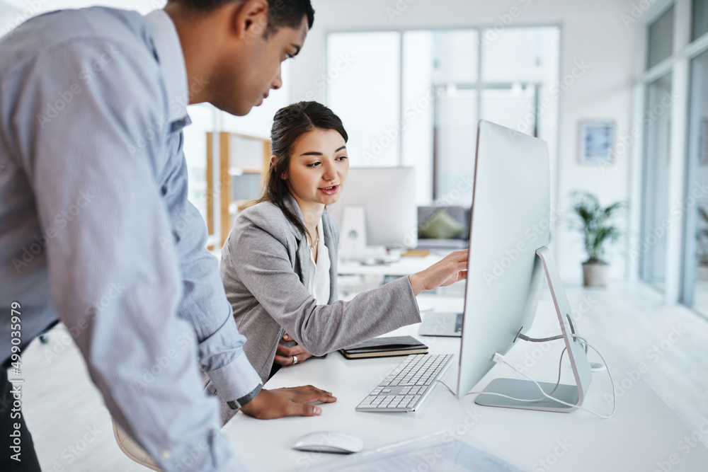 Technology that matches their target driven company. Shot of a young businessman and businesswoman using a computer in a modern office. Technology that matches their target driven company. Shot of a young businessman and businesswoman using a computer in a modern office.