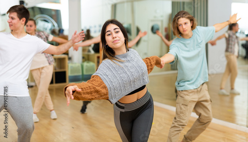 Energetic teens formed pairs and dancing salsa in studio.
