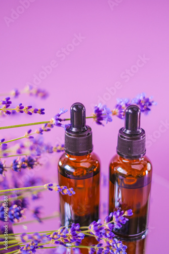 Lavender oil.Aromatherapy and massage.Brown glass bottles oil set and lavender flowers on a purple background.aroma of lavender.Essence with lavender scent. 