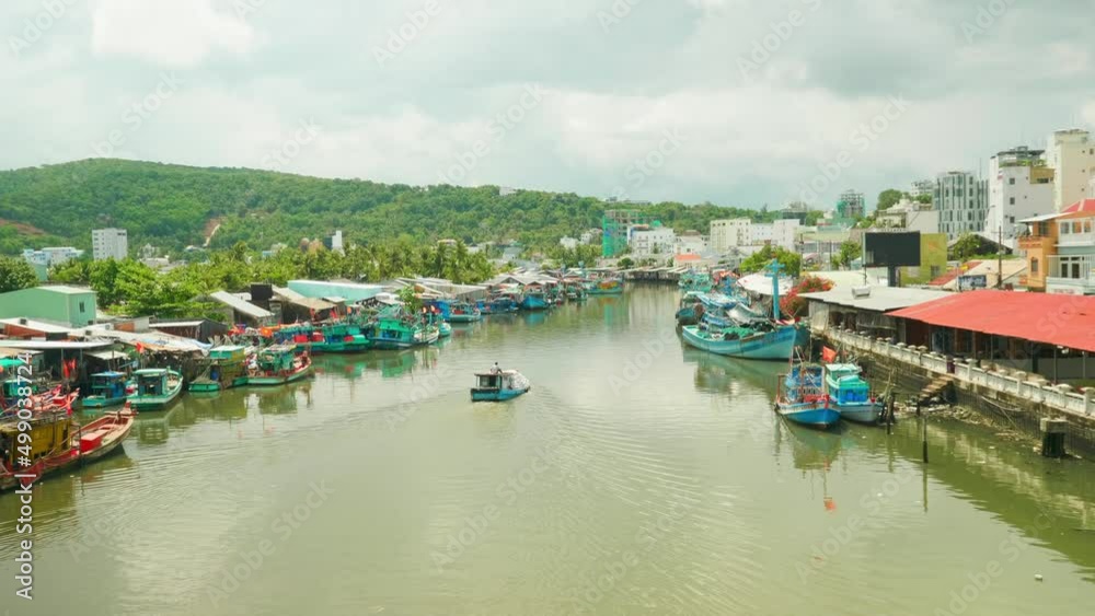 Little wooden boat sailing a river in tropical picturesque floating village Little wooden boat sailing a river in tropical picturesque floating village