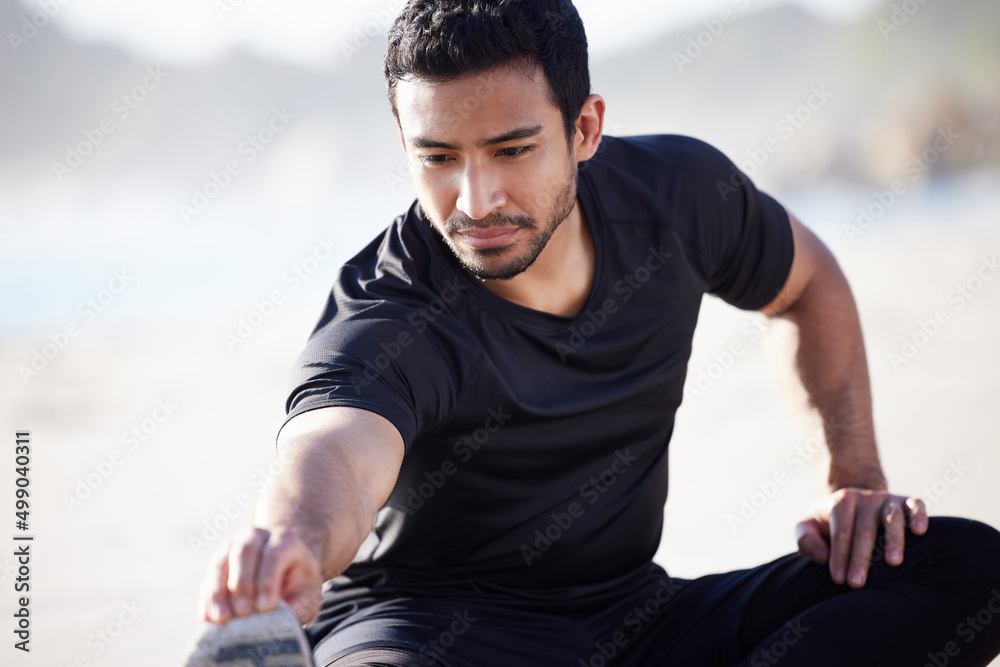Getting his body ready for a workout. Cropped shot of a handsome young male athlete warming up before his workout on the beach. Getting his body ready for a workout. Cropped shot of a handsome young male athlete warming up before his workout on the beach.