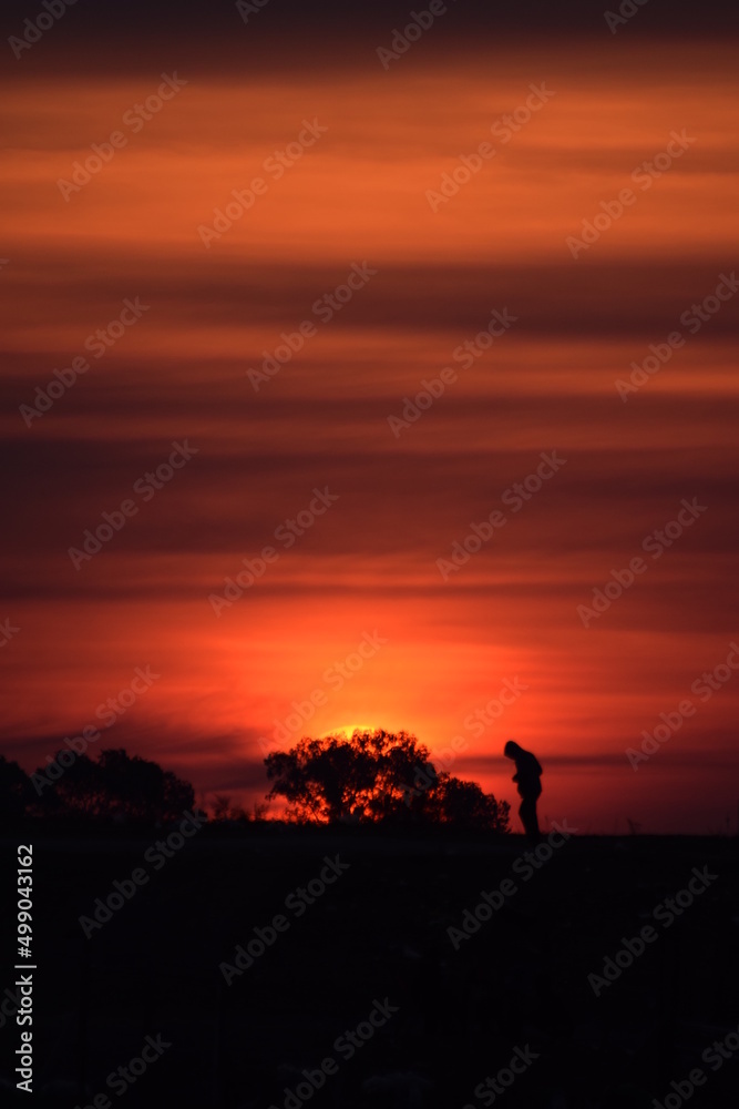 silhouette of a person walking on a sunset