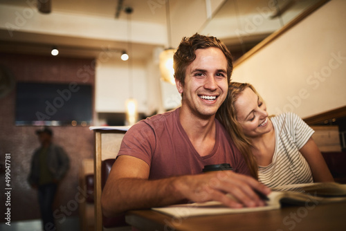 Maybe its time for a study break. Portrait of a happy young student couple studying together at a cafe.
