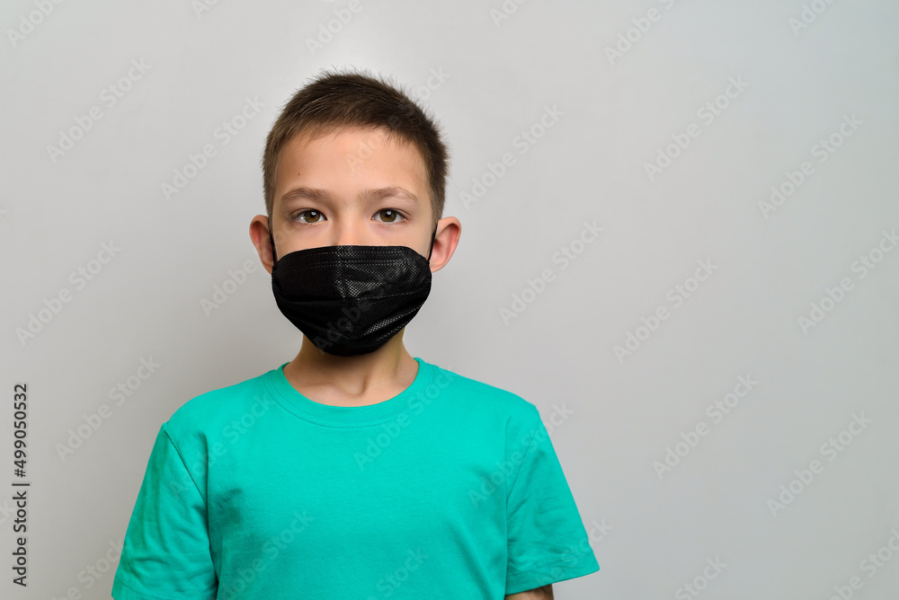 Kid boy portrait wearing a medical face mask for protection from viruses on white background Kid boy portrait wearing a medical face mask for protection from viruses on white background